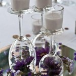 Elegant DIY purple centerpiece table with three wine glasses filled with purple flowers and candles