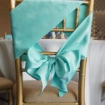 A Quinceanera chair decorated with a blue sash