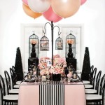 Quinceanera celebration: A table adorned with black and pink decorations, featuring a bunch of balloons on top of it