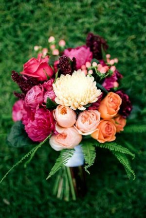 Quinceanera flower ideas, a bouquet of flowers sitting on top of a lush green field