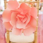 A chair with a flower on top of it surrounded by cut flowers for a Quinceanera celebration
