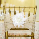 Quinceanera table with a chair featuring a white flower on top