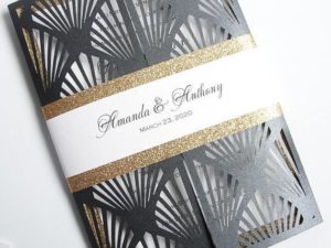 A close up of a Quinceanera card with gold glitter on a Hollywood themed background.