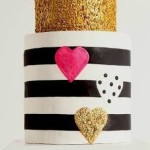 A Quinceanera themed cupcake, featuring a three-tiered cake with gold and black stripes.