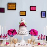 A table with a Quinceanera cake and cupcake, decorated with intricate frosting designs