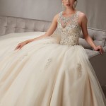 A woman sitting on a couch wearing a Quinceanera dress, gown Quinceañera dresses