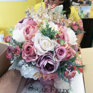 A person holding a box of Quinceanera floral design bouquet