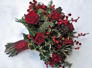 A stunning Quinceanera bouquet featuring red roses, pine cones, and holly in the wedding flowers bridal bouquet