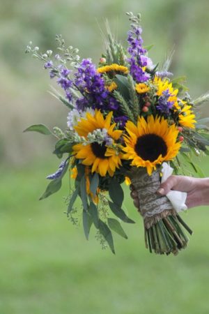 Quinceanera: A bride holding a bouquet of sunflowers and other flowers