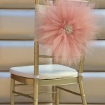 A table with a chair and a pink flower on top of it, representing a Quinceanera celebration