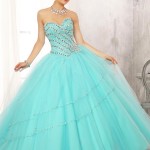 A woman in a turquoise Quinceañera dress posing for a picture.