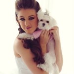 Quinceanera image of a woman in a white dress holding a Maltese dog