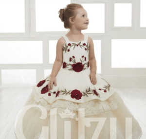 A Quinceanera theme image featuring a gown and a flower girl, a little girl in a dress sitting on the floor