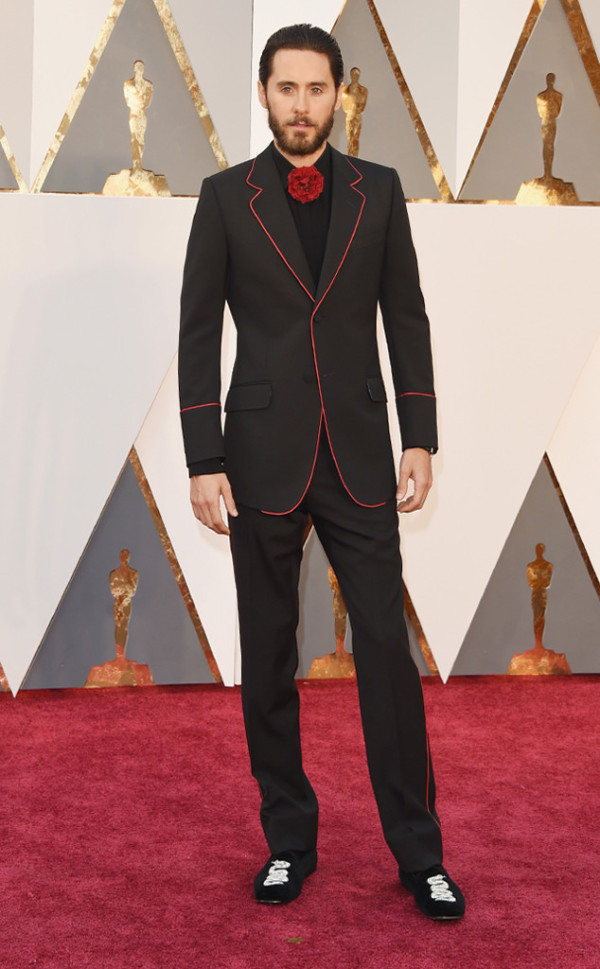 Jared Leto, a man in a tuxedo standing on a red carpet at a Quinceanera event