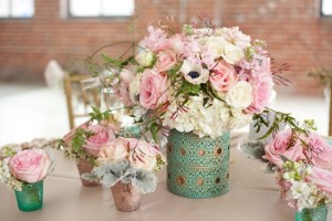 A beautiful floral bouquet and a table filled with vases of pink and white flowers, perfect for a Quinceanera celebration.