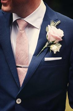 A close up of a person wearing a navy blue and pink Quinceanera suit