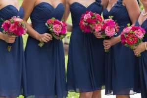 A group of women standing next to each other holding bouquets, wearing rose poudre et bleu marine Quinceanera dresses