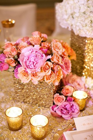A Quinceanera themed centrepiece featuring a table topped with a vase filled with flowers and candles