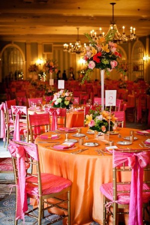 A Quinceanera image featuring a table set up with pink and orange linens surrounded by black decor