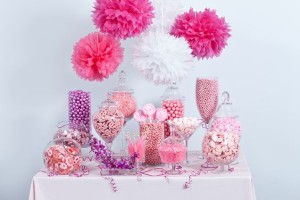 A pink candy bar with lots of pink and white candy, including a table topped with a Lollipop.