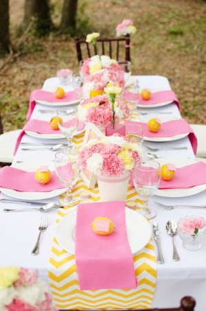 Quinceanera image: A table set with pink and yellow place settings for a Quinceanera celebration