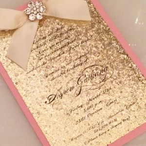 A pink and gold Quinceanera invitation with a bow