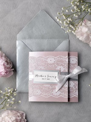 A pink and silver Quinceanera invitation with a ribbon