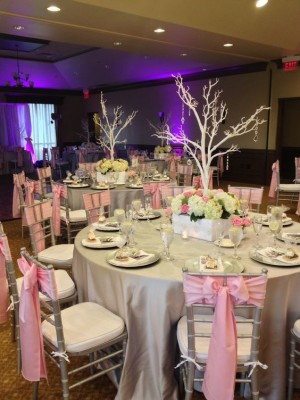 A table set up for a Quinceanera reception with a blush pink theme