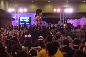 Fashion, a woman in a black and pink dress on a stage at a Quinceanera