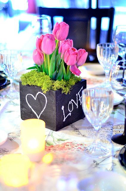 A Quinceanera-themed centrepiece featuring a table adorned with a vase of flowers and candles