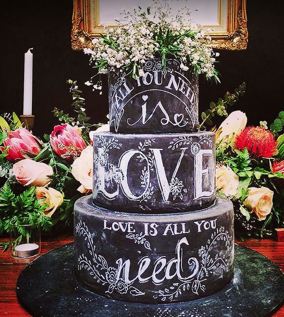 A Quinceanera cake with three tiers and chalk lettering on it