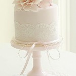 Quinceanera cake, a white cake with a pink flower on top