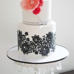 Quinceanera cake, a white cake with black lace and flowers on top