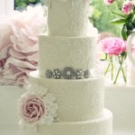 A three-tiered Quinceanera cake with pink flowers