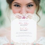 A person holding a purple paper cut out of paper with a Quinceanera invitation design