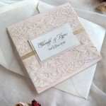 A close up of a red and white Quinceanera invitation, featuring fashionable details.