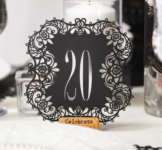 A close up of a table with a table number featuring Elisa Viesta & Co cup at a Quinceanera celebration