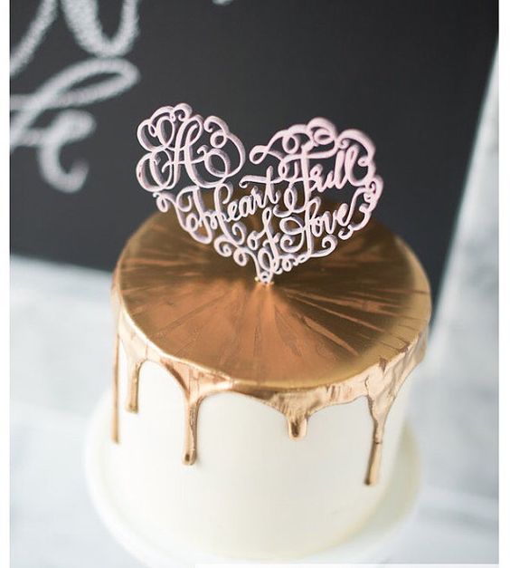A Quinceanera cake with gold drips, decorated with a happy birthday cake topper made of chocolate