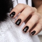 Quinceanera image: Short geometric nail designs featuring a woman's hand with a black and white manicure