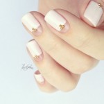 A woman's hand holding a pink and white manicure with nail designs for a Quinceanera.