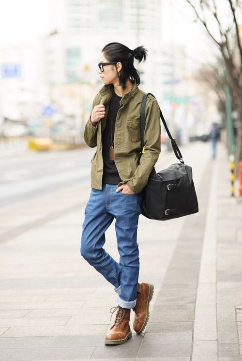 A man walking down a sidewalk carrying a bag, wearing jeans at a Quinceanera celebration