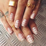 Quinceanera themed image: A woman's hand with a pink and white checkered manicure, showcasing nail designs