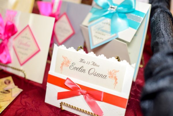 A table topped with lots of different types of cards, Quinceañera favors