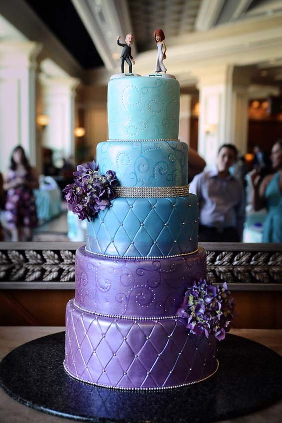 A Quinceanera cake with three tiers, decorated with tiffany blue and purple frosting.