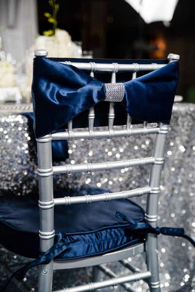 A navy blue and silver winter Quinceanera theme. A chair with a blue bow tie on it.