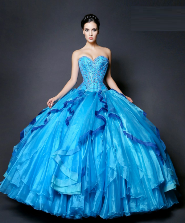 A woman in a blue Quinceanera dress, posing for a picture