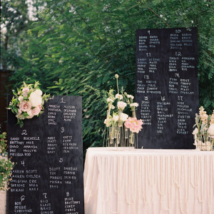 A Quinceanera-themed image featuring a table topped with a white table cloth covered in flowers and a grave Flower