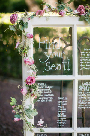 A Quinceanera seating chart table with a window frame and a seating card attached to it