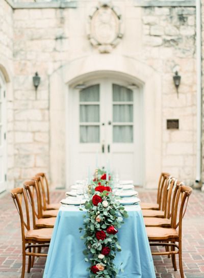 A beautifully decorated dining room with a Quinceanera theme. The table is covered with a blue table cloth and adorned with flowers.