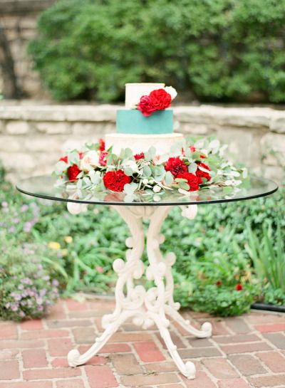 Floral design with a flower bouquet and a Quinceanera cake with red roses on a table